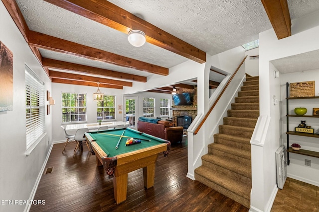 rec room featuring dark wood-type flooring, a fireplace, billiards, a textured ceiling, and beamed ceiling