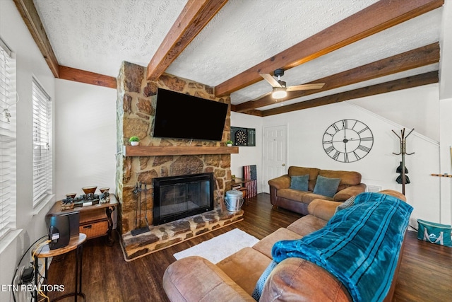 living room featuring ceiling fan, dark wood-type flooring, a textured ceiling, and a fireplace