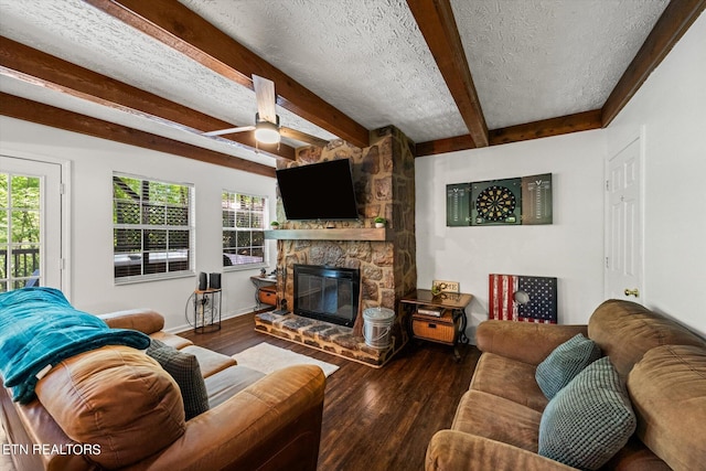 living room featuring a textured ceiling, ceiling fan, dark wood-type flooring, and a stone fireplace