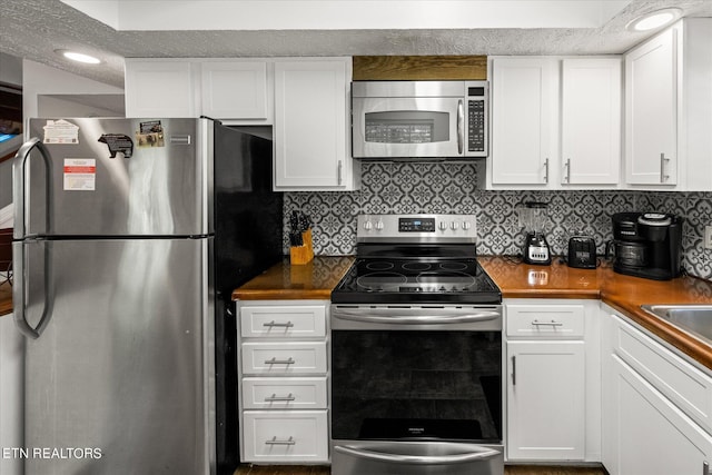 kitchen featuring appliances with stainless steel finishes, backsplash, and white cabinets