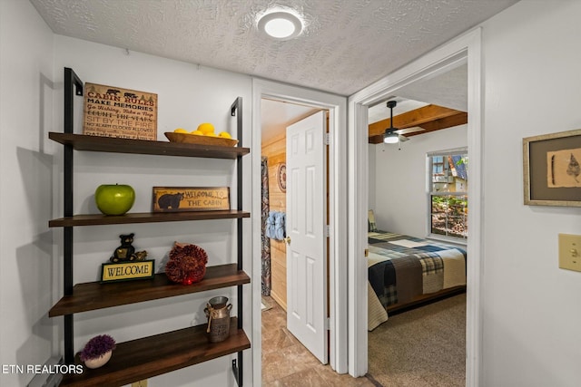 hallway featuring a textured ceiling and light colored carpet