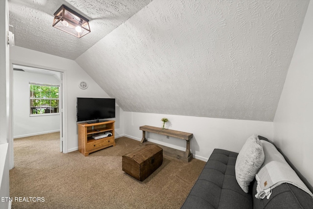 carpeted living room featuring a textured ceiling and lofted ceiling