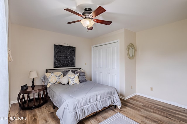 bedroom with light hardwood / wood-style flooring, a closet, and ceiling fan