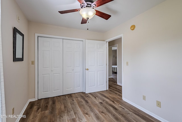 unfurnished bedroom with wood-type flooring, a closet, and ceiling fan