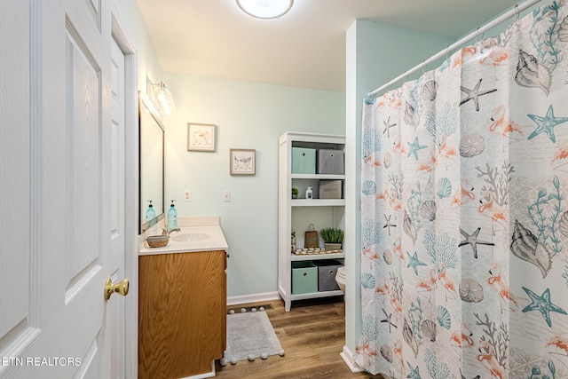 bathroom with wood-type flooring, toilet, and vanity