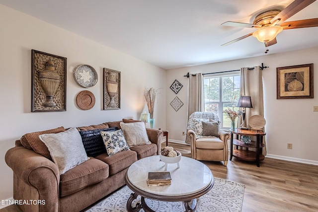 living room with light wood-type flooring and ceiling fan