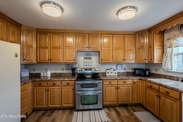 kitchen with sink, range with two ovens, white fridge, and dark hardwood / wood-style flooring