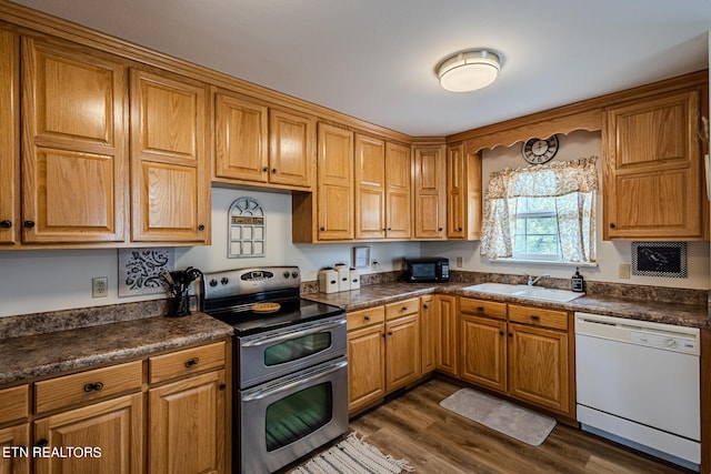 kitchen featuring sink, dark hardwood / wood-style flooring, white dishwasher, and double oven range