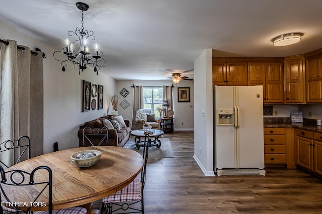 kitchen featuring ceiling fan with notable chandelier, white fridge with ice dispenser, hardwood / wood-style floors, and pendant lighting