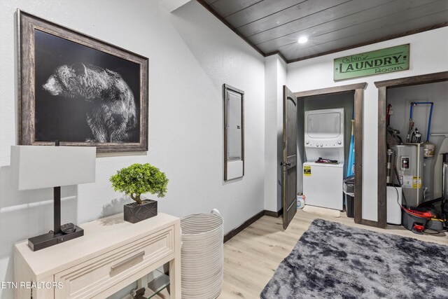 interior space with wooden ceiling, light hardwood / wood-style floors, crown molding, water heater, and stacked washer and dryer