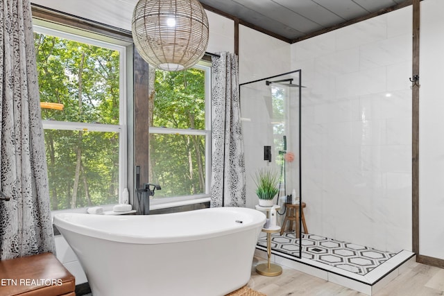 bathroom with independent shower and bath and hardwood / wood-style floors