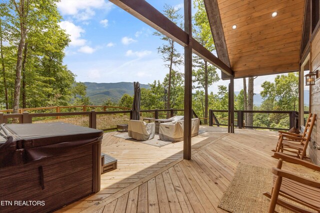 deck with a mountain view and a hot tub