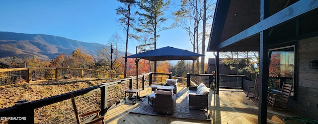 wooden terrace featuring an outdoor hangout area and a mountain view