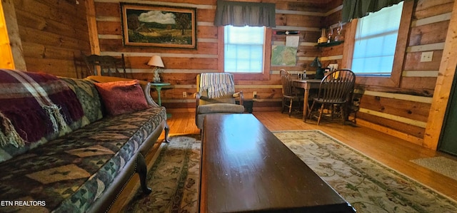 living room with wood-type flooring and wooden walls