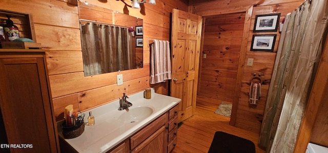 bathroom featuring wood walls, vanity, and curtained shower