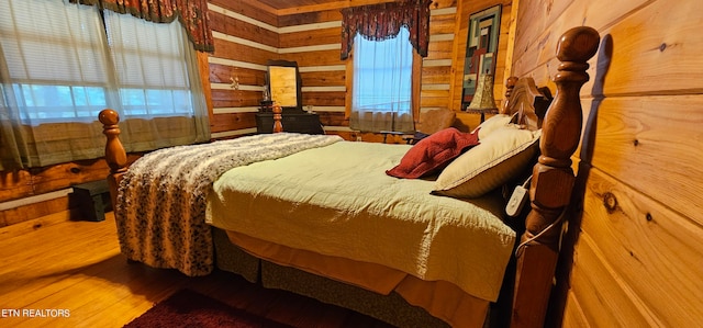 bedroom with wood-type flooring and wood walls