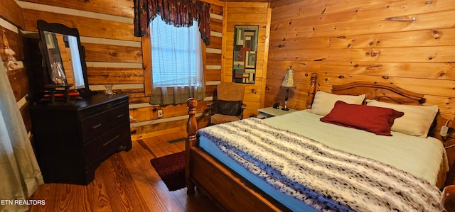 bedroom featuring dark hardwood / wood-style floors and wood walls