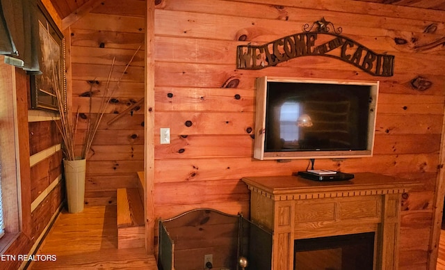 living room with light hardwood / wood-style flooring and wooden walls