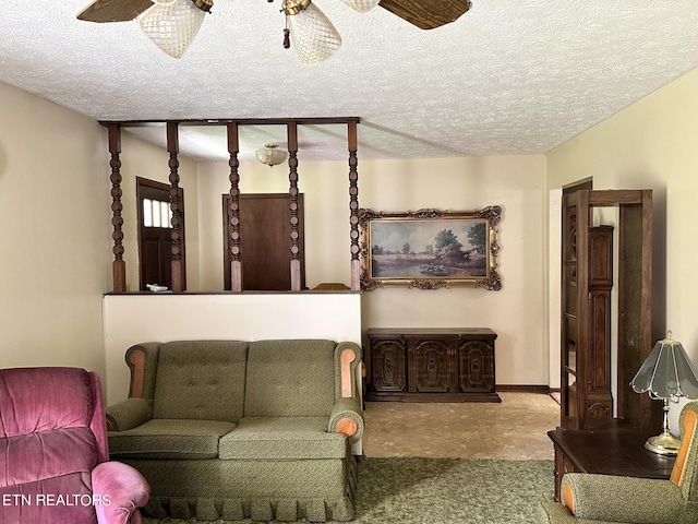 living room featuring ceiling fan and a textured ceiling