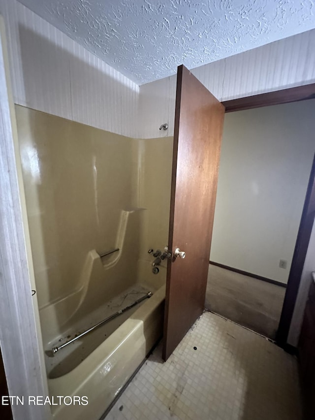 bathroom featuring a textured ceiling and  shower combination