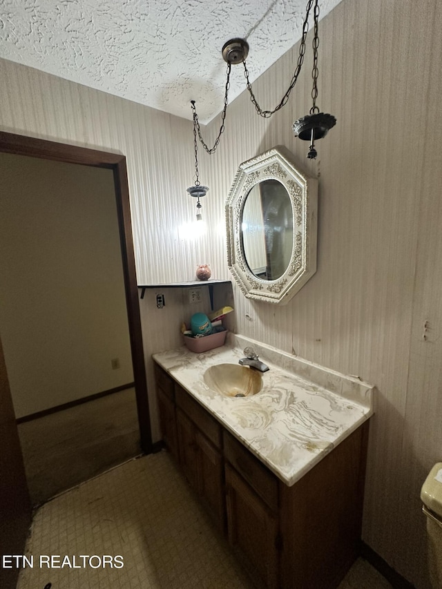 bathroom featuring a textured ceiling, tile patterned flooring, and vanity