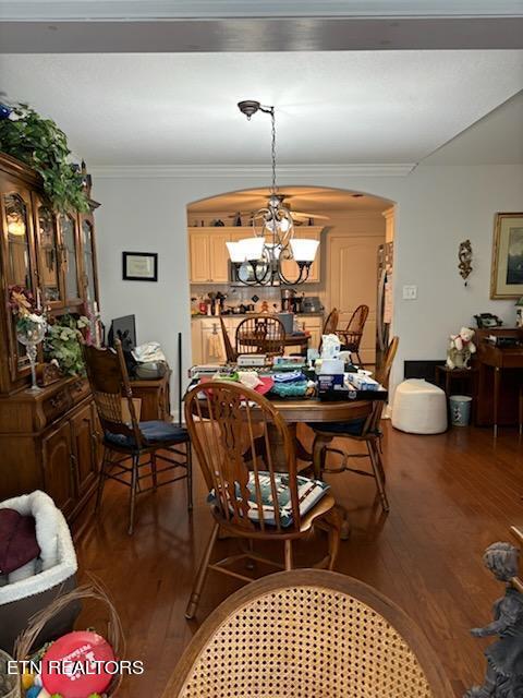 dining space with a chandelier, wood-type flooring, and ornamental molding