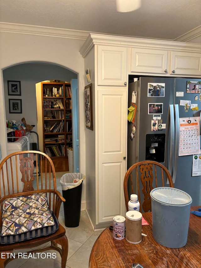 kitchen featuring white cabinetry, tile patterned floors, stainless steel fridge with ice dispenser, crown molding, and washer / clothes dryer