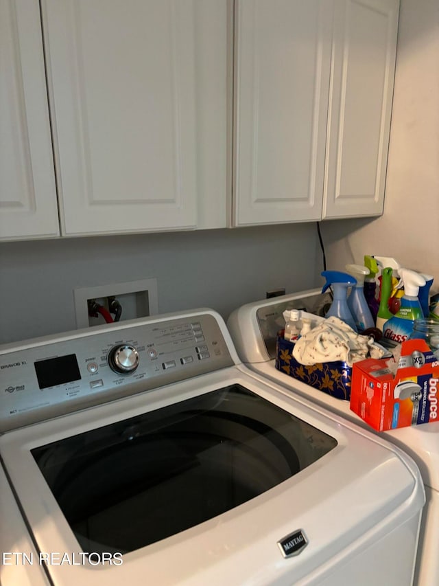 washroom with washing machine and dryer and cabinets