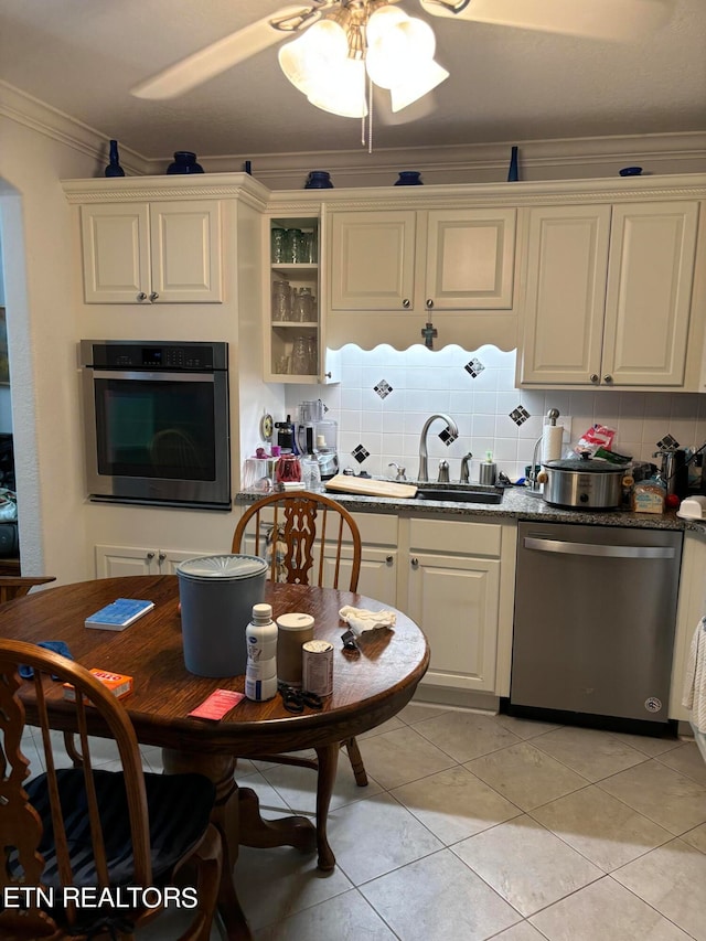 kitchen with white cabinetry, crown molding, ceiling fan, appliances with stainless steel finishes, and decorative backsplash