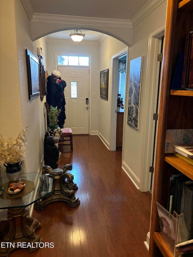 foyer with wood-type flooring and crown molding