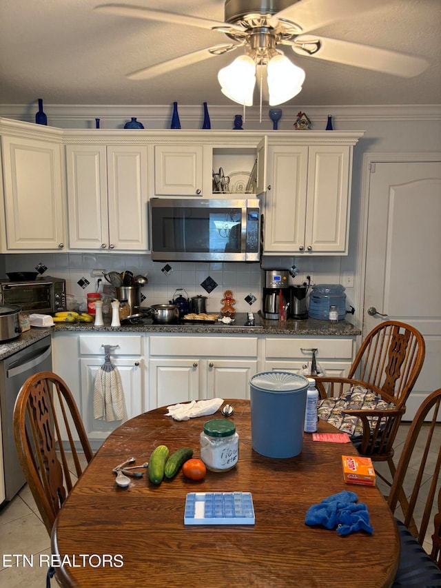 kitchen with white cabinetry, ceiling fan, crown molding, appliances with stainless steel finishes, and backsplash