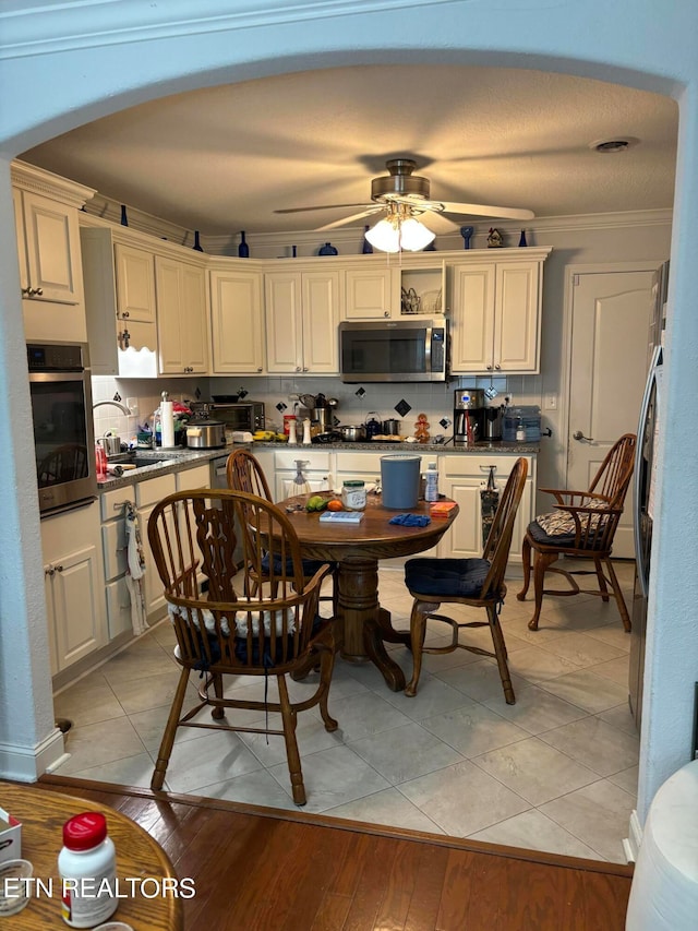 dining space featuring sink, crown molding, ceiling fan, and light hardwood / wood-style floors