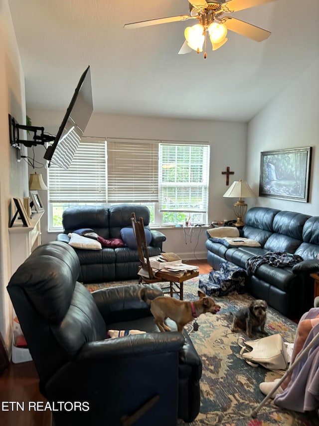 living room with ceiling fan, hardwood / wood-style flooring, and vaulted ceiling