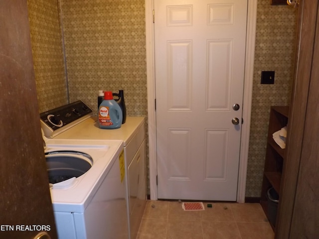 laundry room featuring washing machine and clothes dryer and light tile patterned floors