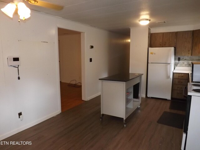 kitchen featuring dark wood-type flooring, ceiling fan, backsplash, and white appliances