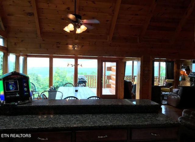 kitchen featuring lofted ceiling with beams, ceiling fan, wooden ceiling, and wooden walls