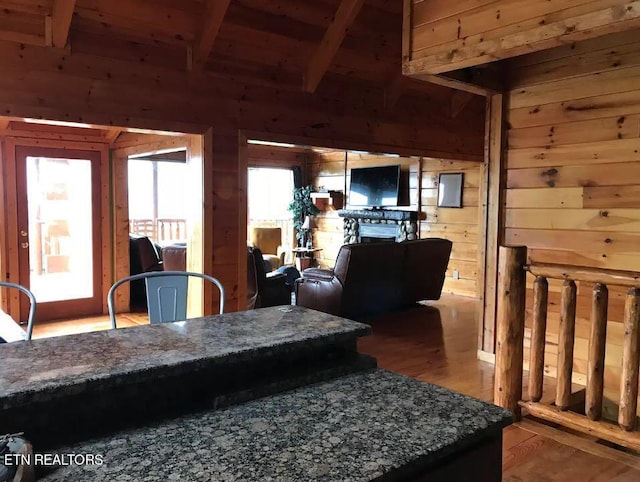 living room with hardwood / wood-style flooring, wooden walls, wooden ceiling, and beamed ceiling