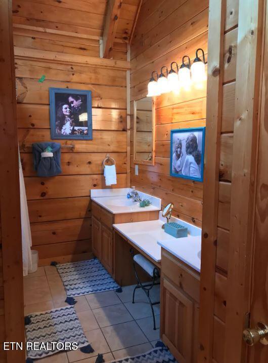 bathroom featuring tile patterned flooring, vanity, wooden ceiling, and wood walls