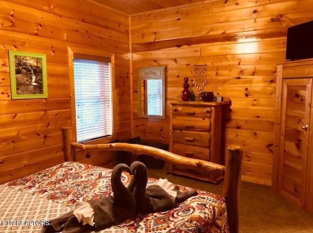 carpeted bedroom featuring wood walls