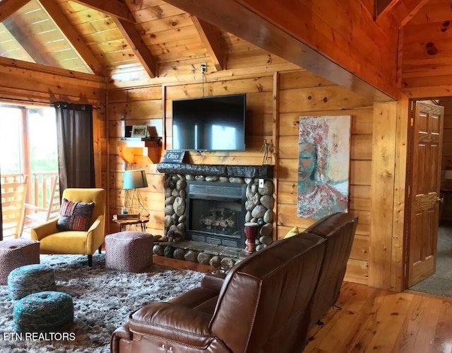 living room featuring wood walls, wood ceiling, lofted ceiling with beams, hardwood / wood-style flooring, and a fireplace