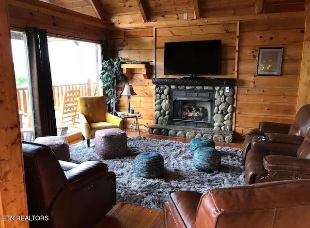 living room featuring vaulted ceiling, hardwood / wood-style floors, a fireplace, wooden walls, and wooden ceiling