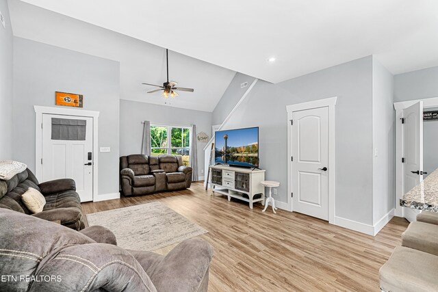 living room with vaulted ceiling, light hardwood / wood-style floors, and ceiling fan