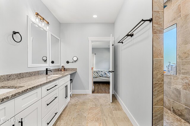 bathroom featuring tiled shower and vanity