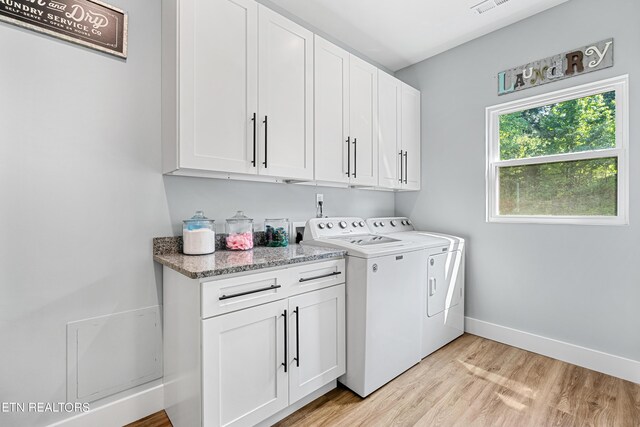 laundry room featuring cabinets, separate washer and dryer, and light wood-type flooring