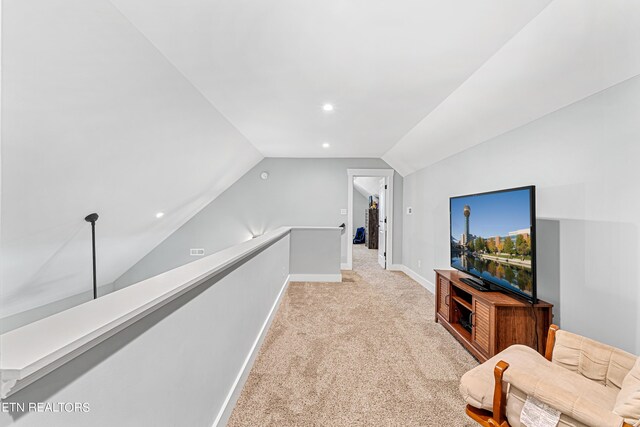 interior space featuring vaulted ceiling and light carpet