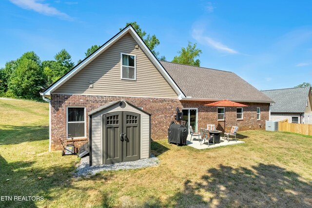 rear view of house with a storage unit, a patio area, and a lawn