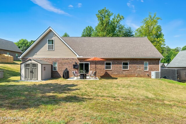 back of house with a yard, cooling unit, a patio area, and a storage shed