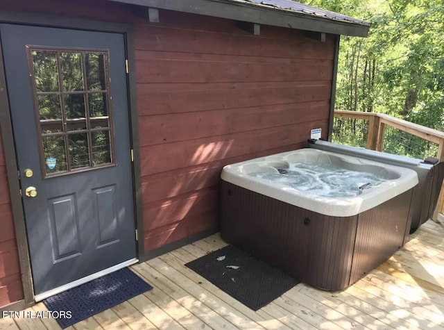 wooden deck featuring a hot tub