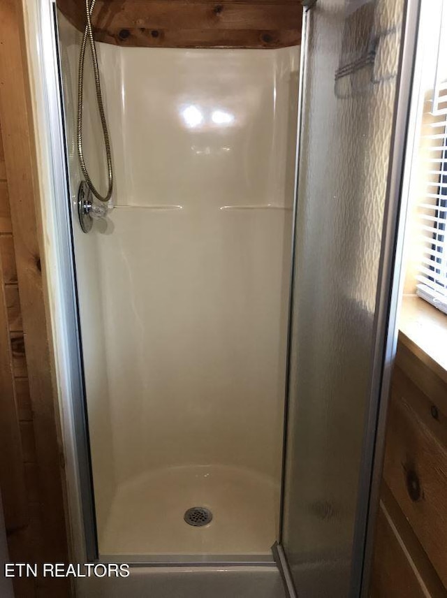 bathroom featuring a shower with door