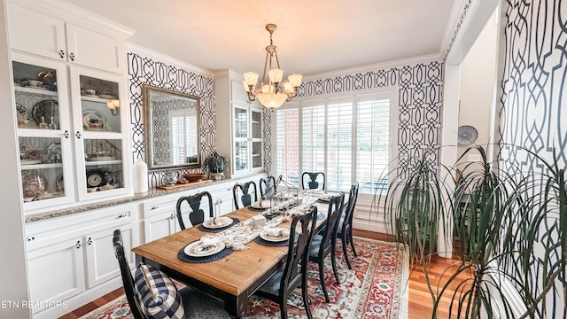 dining room with light hardwood / wood-style floors, ornamental molding, and a chandelier